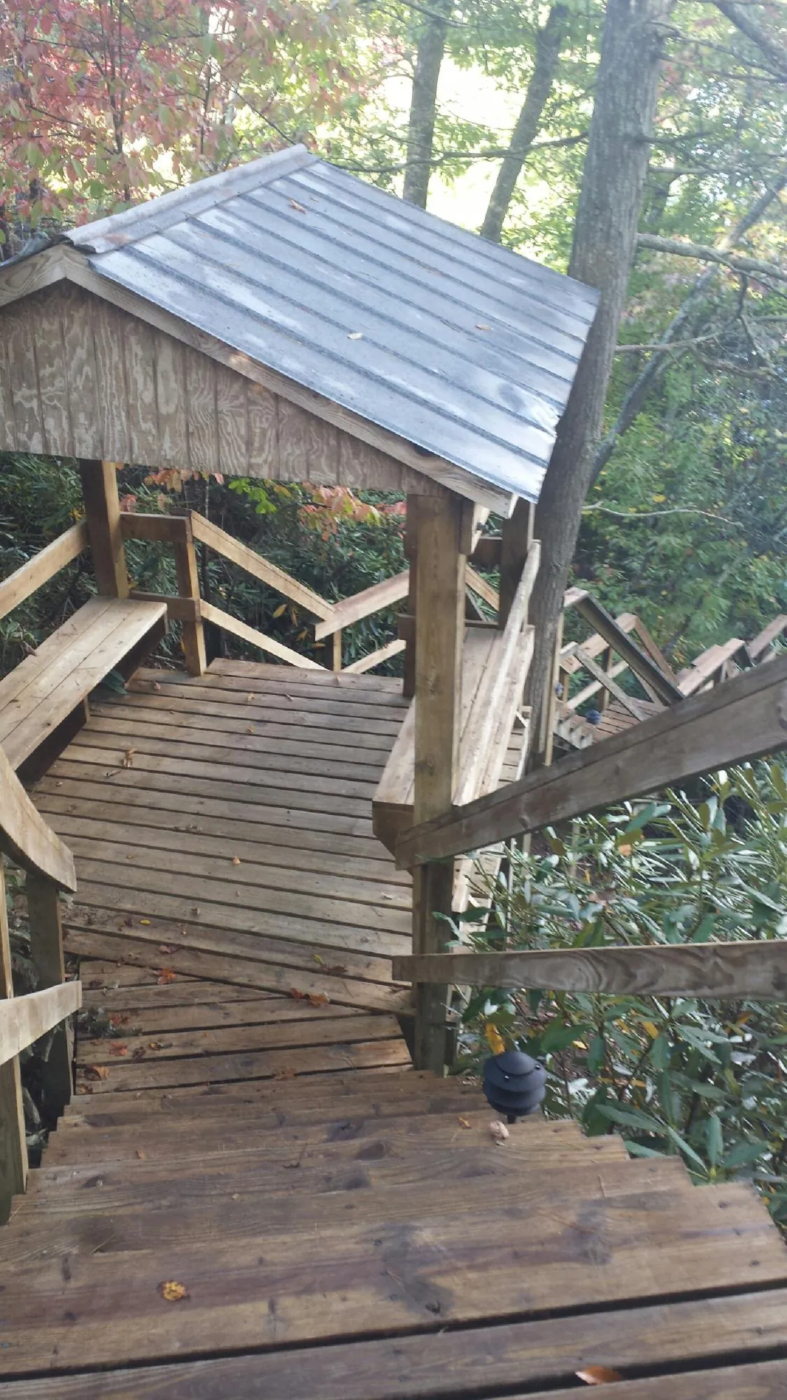 Metal roofed shelter over wooden steps on a wooded walkway — Skylight Repair & Installation work by our crew in Linesville